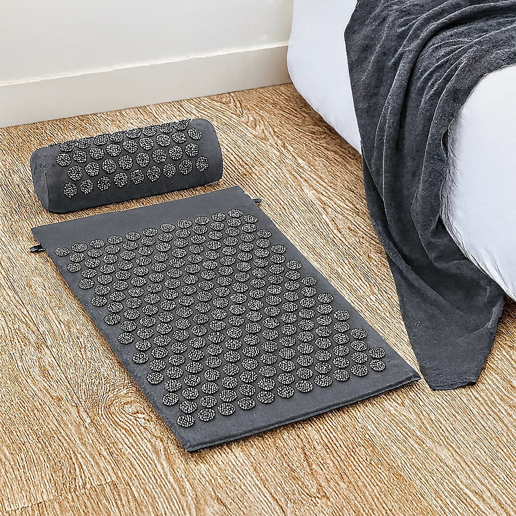Kit d'acupression gris installé au sol, tapis et coussin