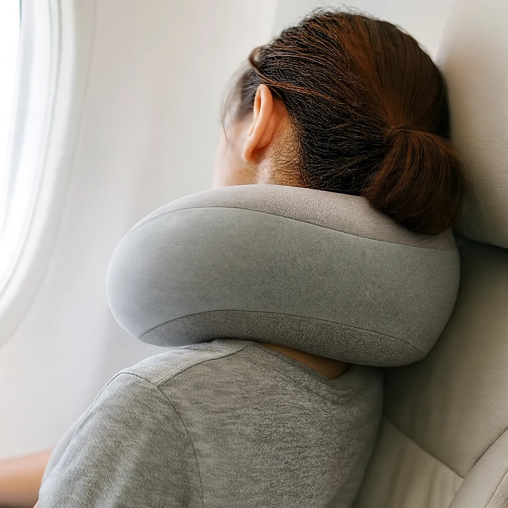 Oreiller de voyage gris perle porté en avion