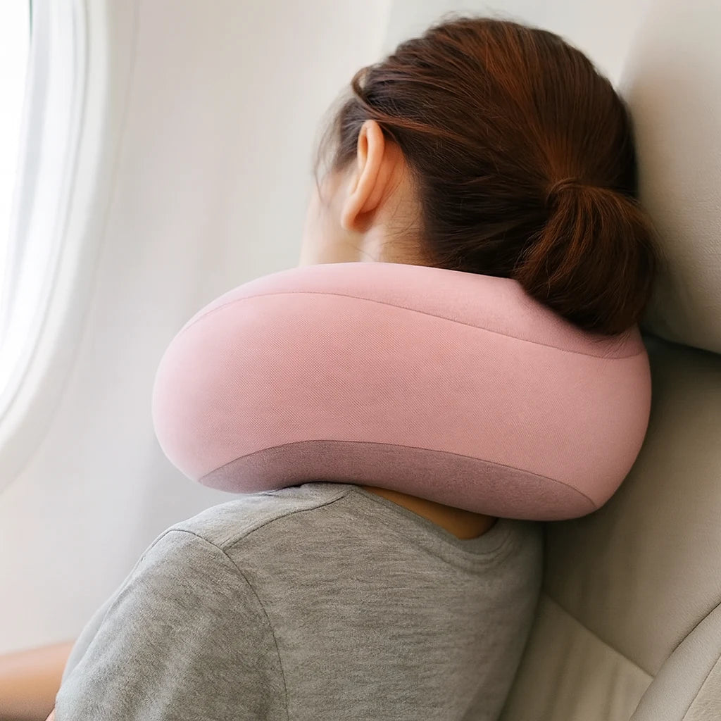 Oreiller de voyage rose poudré porté en avion